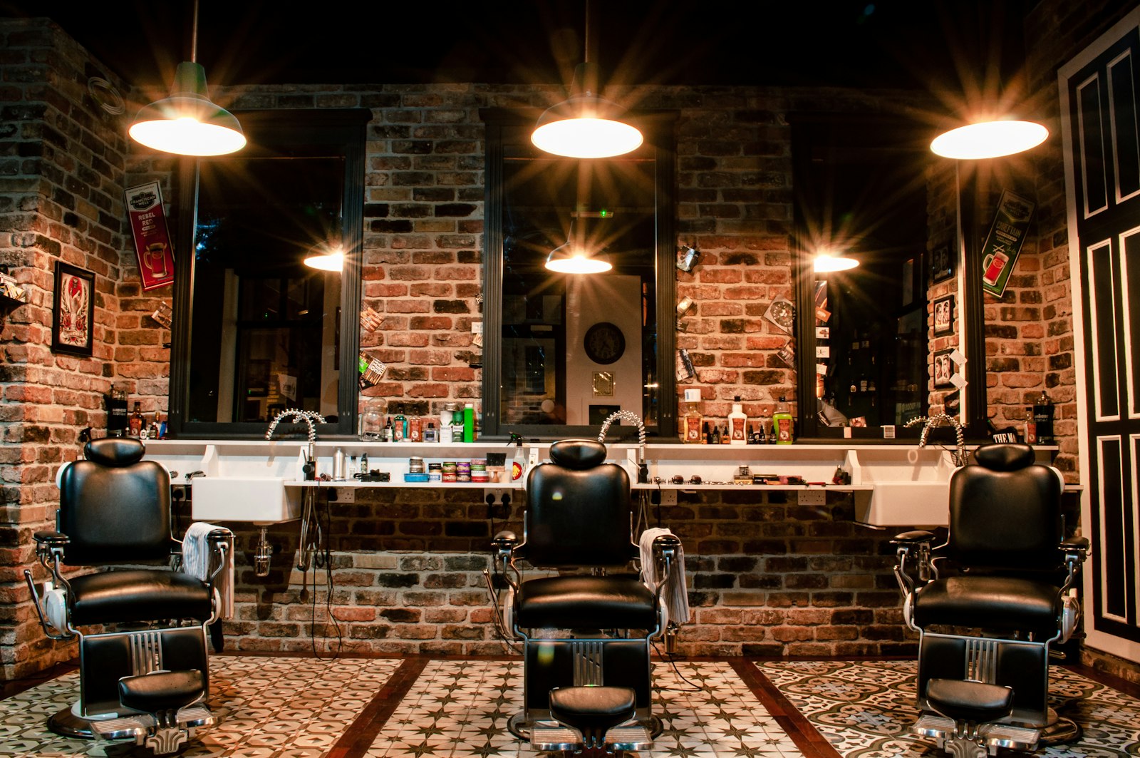 Stilvolles Interieur des Barber Shop Viersen mit klassischen Barber-Stühlen, Backstein und warmem Licht